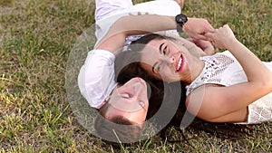 Young teen couple in love lie in the Park on the grass in summer.