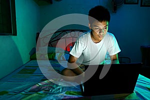 Young Teen in front of a laptop computer and on a bed