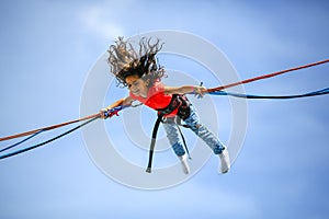 Young teen girl in bungee jumping trampoline