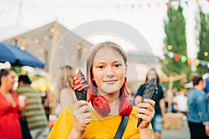 Young teen girl holding red and black ice cream