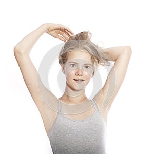 Young teen girl holds blond hair up against white background