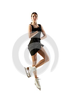 Young teen girl, junior female figure skater in black stage costume skating isolated over white background. Concept of