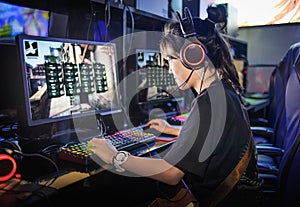 young teen girl playing computer games in internet cafe