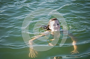 Young teen girl swimming in water 2