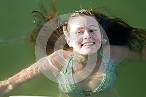 Young teen girl swimming in water