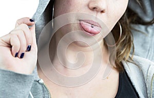 Young teen girl with tongue piercing and hoodie