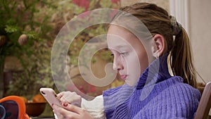 Young teen girl typing message on smartphone screen. Teenager girl using phone for texting mobile message in social