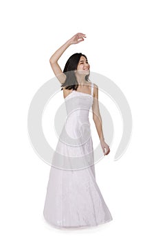 Young teen girl in white dress twirling