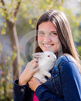 Young teen holding a baby white dwarf rabbit