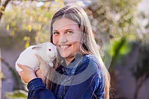 Young teen holding a baby white dwarf rabbit