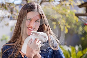 Young teen holding a baby white dwarf rabbit