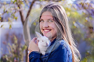 Young teen holding a baby white dwarf rabbit