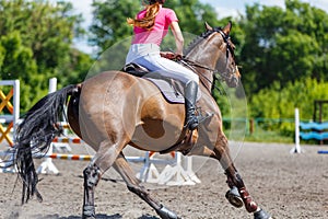Young teen rider girl on show jumping competition