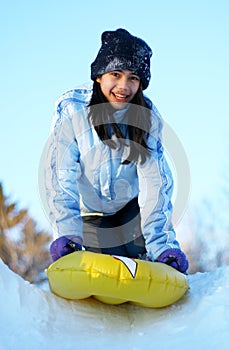 Young teen sledding down hill