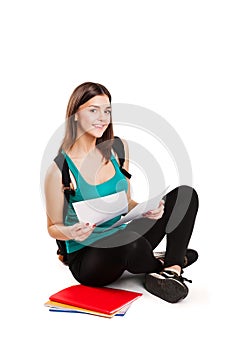 Young teen student sitting on floor with backpack