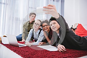 young teen students lying on carpet