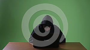 Young teenage boy computer hacker against green background