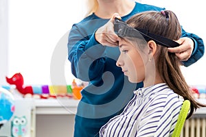 Young teenage girl and child therapist during EEG neurofeedback session. Electroencephalography concept.