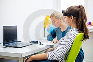 Young teenage girl and child therapist during EEG neurofeedback session. Electroencephalography concept.