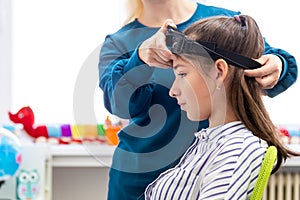 Young teenage girl and child therapist during EEG neurofeedback session. Electroencephalography concept. photo