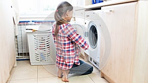 Young teenage girl doing housework in laundry room