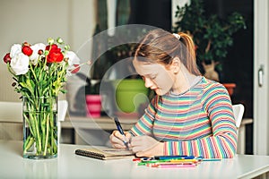 Young teenage girl drawing at home