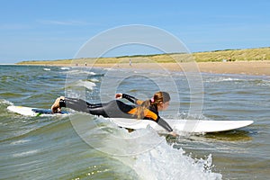 Young teenage girl getting surf lessons on vacation.