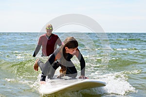 Young teenage girl getting surf lessons on vacation.