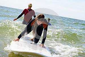 Young teenage girl getting surf lessons on vacation.