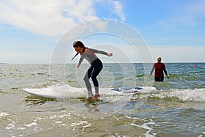 Young teenage girl getting surf lessons on vacation.