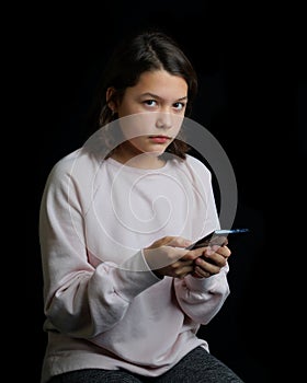 Young teenage girl holding cell phone