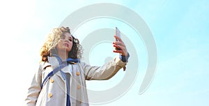 Young teenage girl holding smartphone and take a selfie outdoor. People  travel  nature concept.