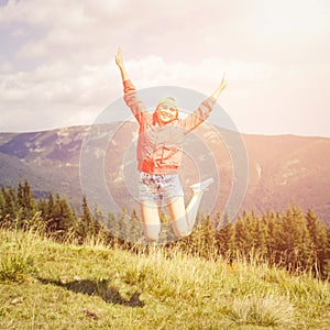 Young teenage girl jumping in mountains