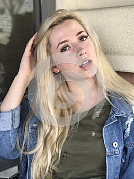 Young teenage girl with long blonde hair and denim jacket