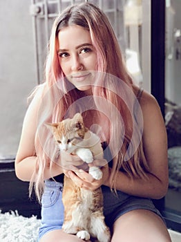 Young teenage girl with long hair holding pet cats