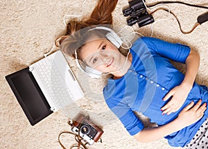 Young teenage girl lying on the floor with laptop