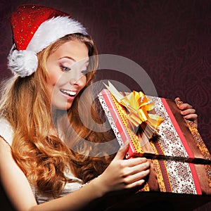 A young teenage girl opening the present