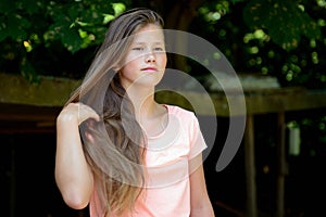 Young teenage girl in the park with facial expression.