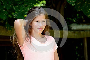 Young teenage girl in the park with smilling facial expression.