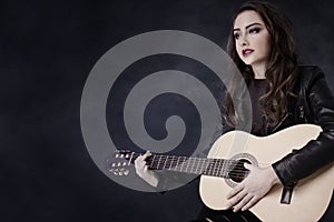 Young teenage girl playing on guitar.