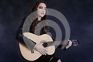 Young teenage girl playing on guitar.