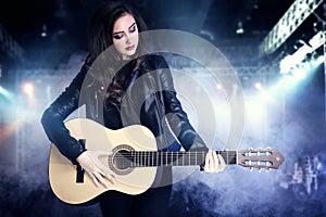 Young teenage girl playing on guitar.