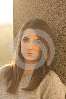 Young teenage girl portrait headshot against wall with serious look