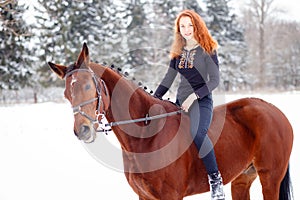 Young teenage girl riding bay horse in winter park
