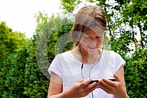 Young teenage girl school girl listening music on her smartphone