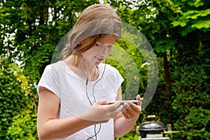 Young teenage girl school girl listening music on her smartphone