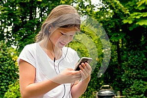 Young teenage girl school girl listening music on her smartphone