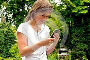 Young teenage girl school girl listening music on her smartphone