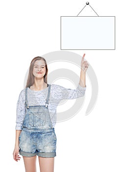 Young teenage girl showing on empty picture frame by finger