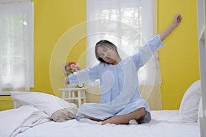 Young teenage girl stretching in bed